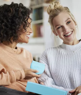 Two women smiling holding the Spark Aligners case 