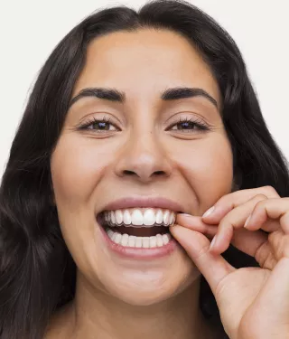 Smiling woman with straight, white teeth, highlighting the effective and discreet results of using Spark clear aligners