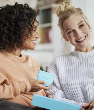 Two women smiling holding the Spark Aligners case