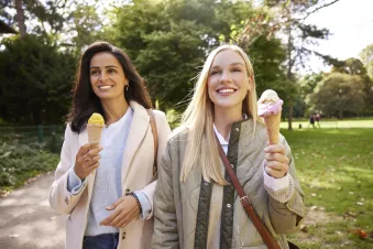 Two women smiling eating ice cream