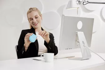 Woman holding Spark Aligners in front of desktop