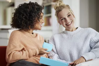 Two women smiling holding the Spark Aligners case