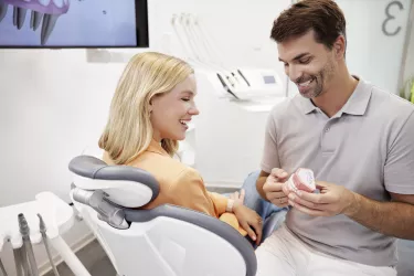 Orthodontist showing a patient the typodont