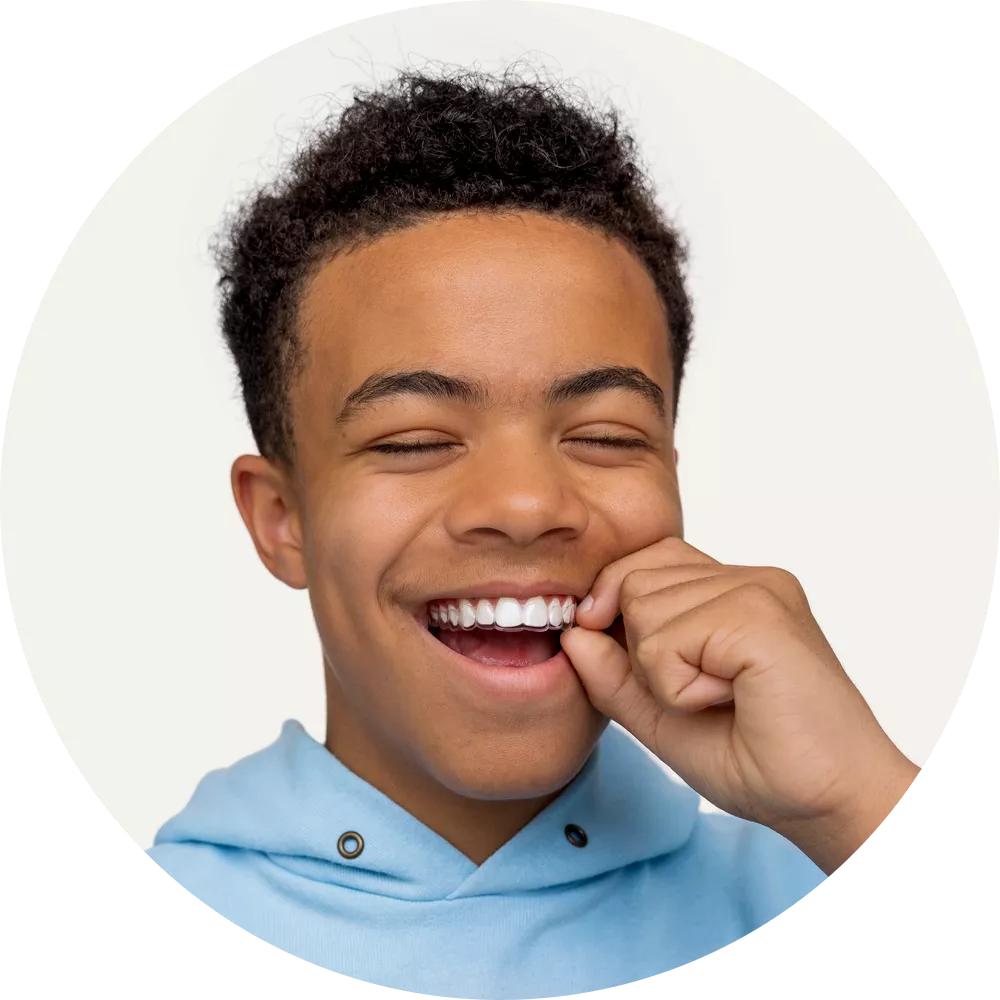 Smiling boy with straight, white teeth, highlighting the effective and discreet results of using Spark clear aligners